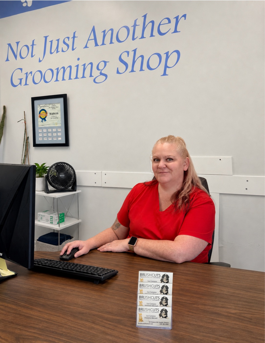 Jenn, the office manager at Brushcuts, at the front desk in Guelph