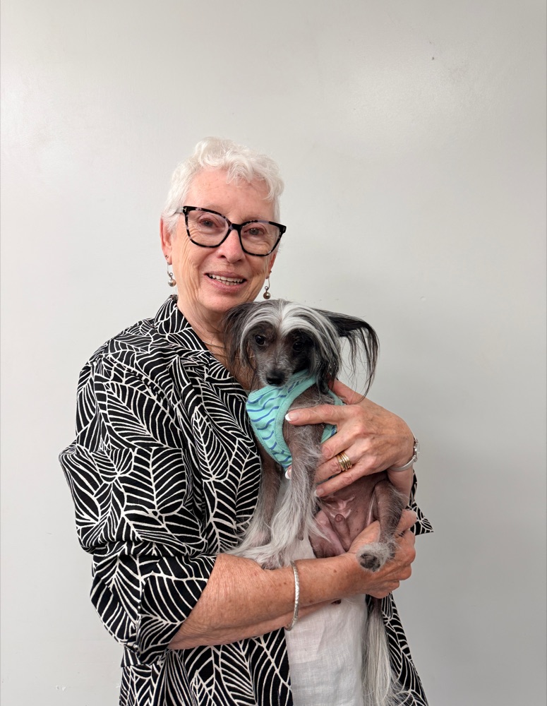 Sharonne, co-owner of Brushcuts, holding a Chinese Crested dog